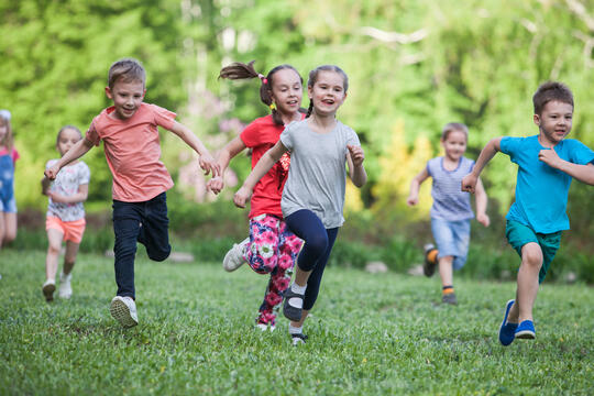 Velkommen til skolestart! Foto med løpende barn fra Adobe Stock foto.