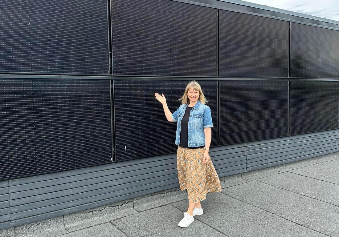 Idun Elisabeth Östgård er fagleder bærekraft, og er her fotografert foran nye, fasademonterte solceller på Ener ungdomsskole.