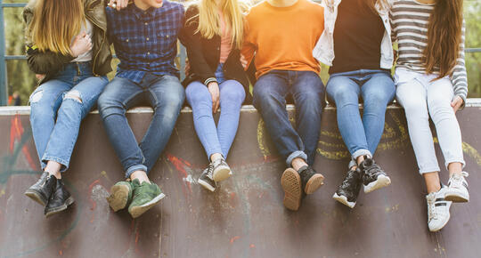 Bilde av ungdom som sitter sammen. Foto: AdobeStock